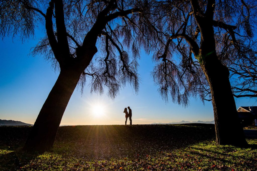 Couple facing each other silhouetted at a park in Seattle