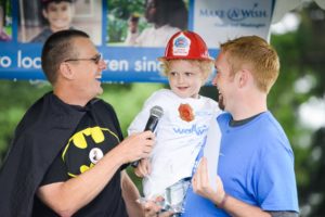 Make-A-Wish CEO talks to child on stage at Wish Walk near Seattle