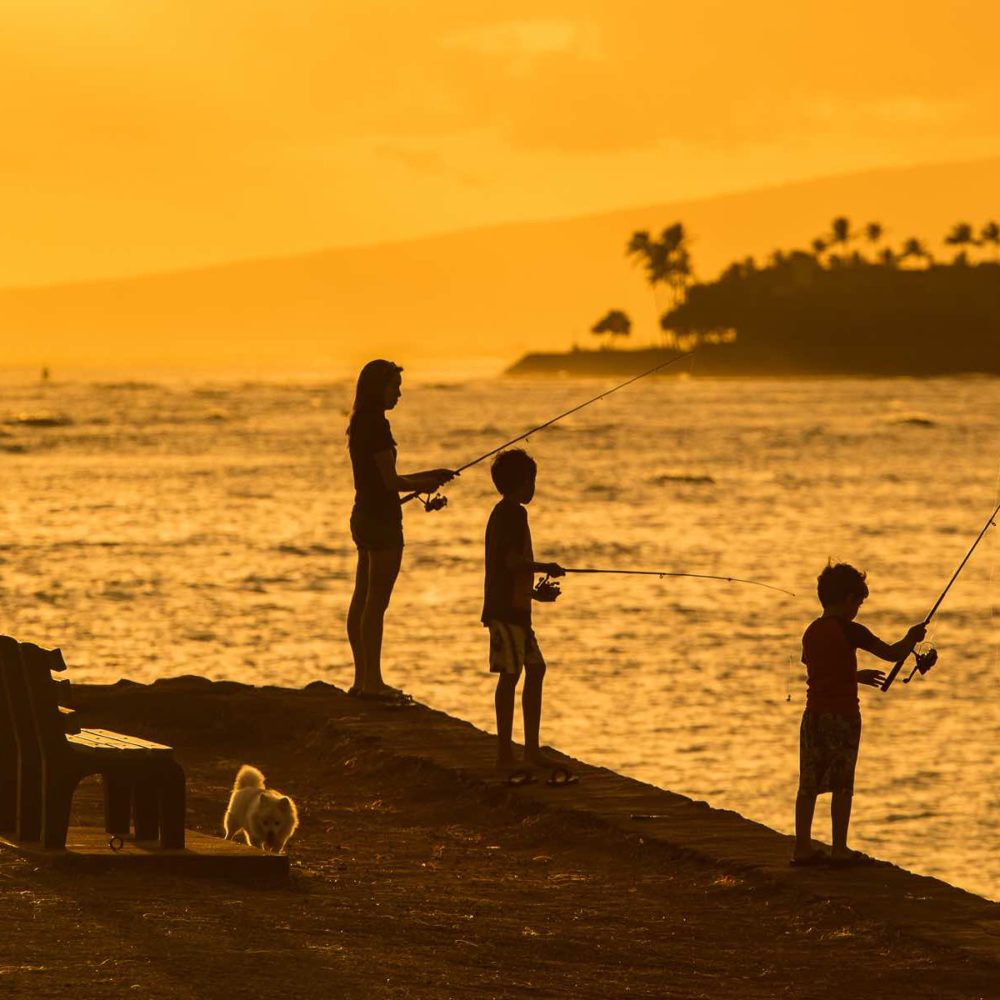 Fishing at a park in Oahu, Hawaii at sunset