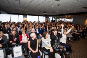Crowd reacts at a conference for non-profit organizations