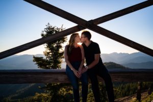 Couple sitting on top of mountain kissing each other