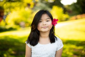Asian girl with white top and red flower in hair