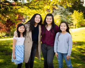 Four Asian sisters close together posing for a photo