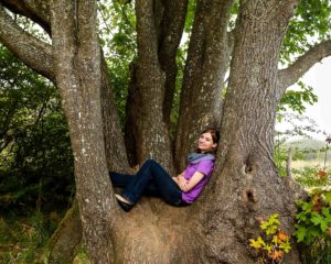 Girl sitting in a tree for her senior photos