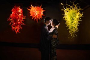 Couple facing each other in dark with Chihuly Glass