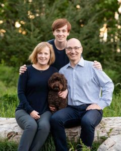 Family with dog smiling at camera