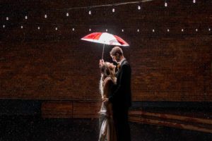 WSU Cougar wedding couple with Coug umbrella in the rain