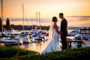 Woodmark Hotel wedding couple holding hands at sunset in front of marina