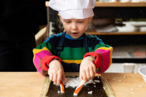Girl makes sushi at Blue Ribbon cooking class for kids