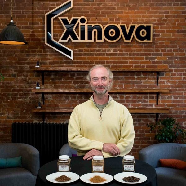 inventor of coffee flour standing behind containers and plates full of coffee flour